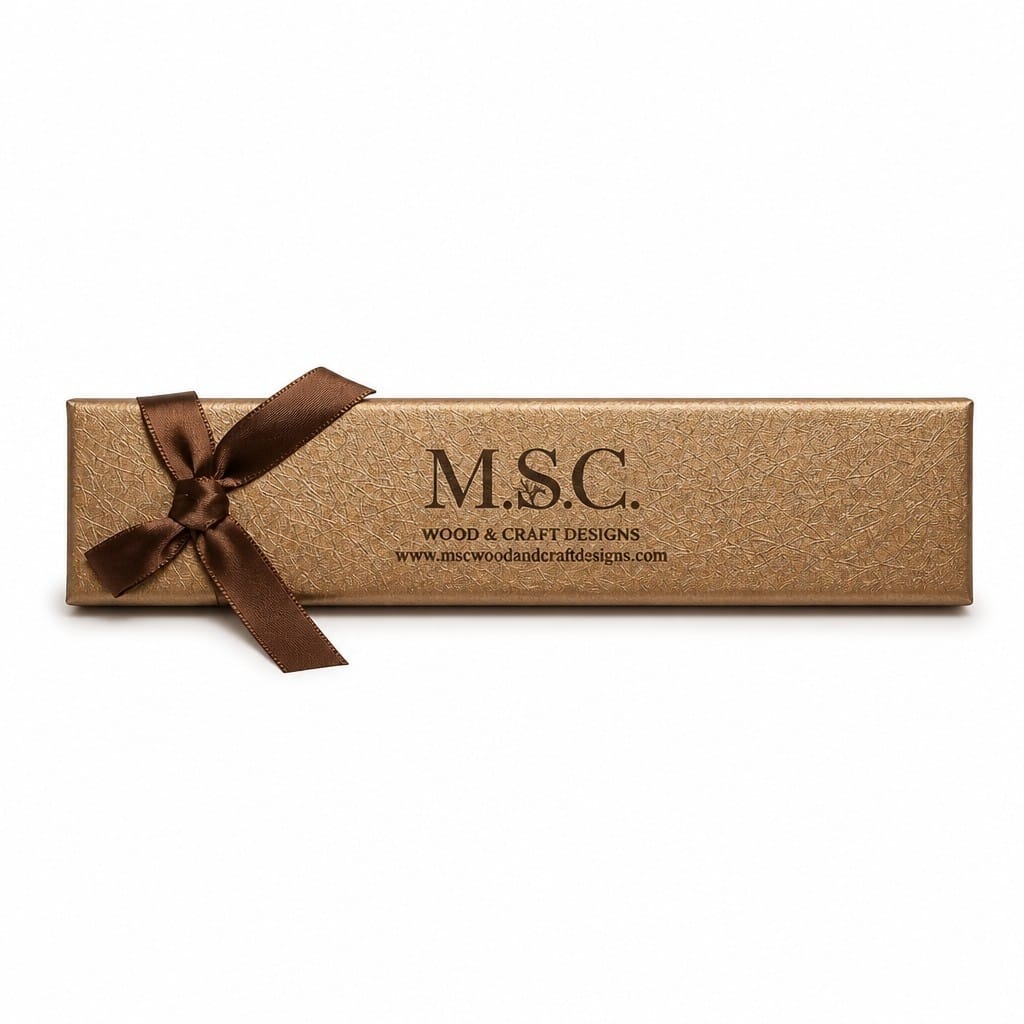 A long, rectangular metallic gold gift box tied with a dark brown satin ribbon, featuring the embossed brand name 'M.S.