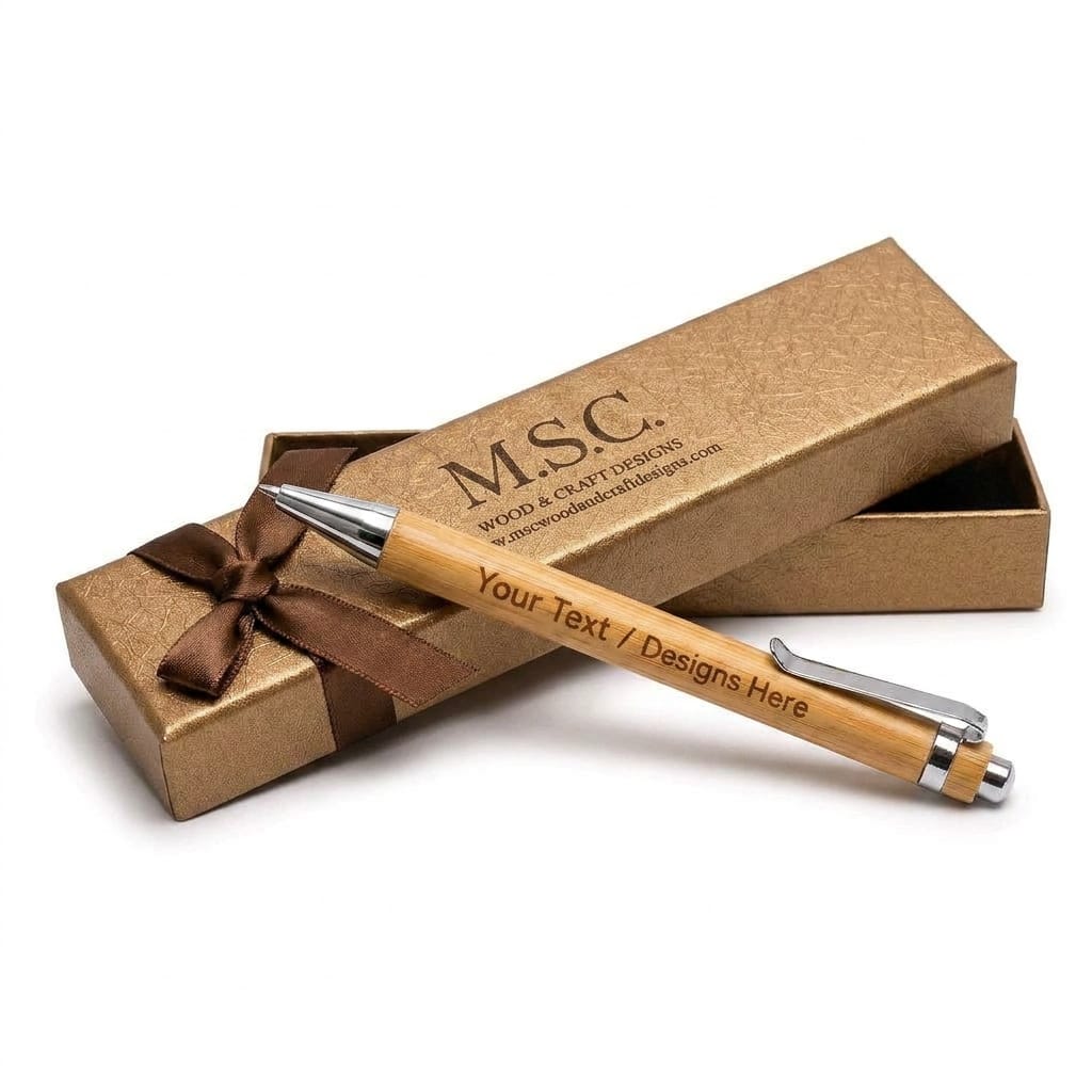 A personalized wooden pen with silver metal accents and engraved text, presented diagonally across a textured gold gift box with a brown ribbon bow. The brand name 'MSC.